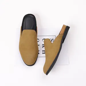 Détail de mocassins en daim camel sans talon avec semelle en caoutchouc noir et design slip-on