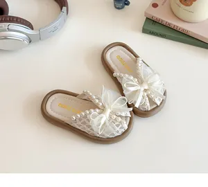 Detalle de las zapatillas de princesa para niña con lazo de encaje blanco y perlas