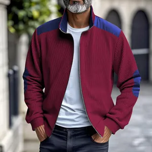 Detail shot of men's burgundy ribbed jacket with blue shoulder patches and zipper.