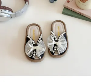 Vista superior de zapatillas para niña con lazo grande de encaje y perlas