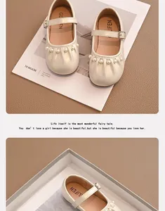 Primer plano de zapatos Mary Jane para niña en color crema con perlas y detalles fruncidos