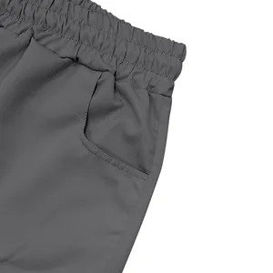 Detailed macro shot of grey athletic cargo shorts showing elastic waistband and pocket seams.