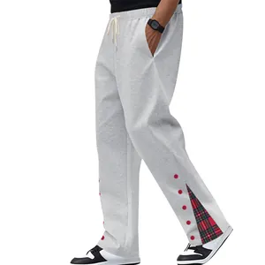 Dettaglio dei pantaloni sportivi grigi pesanti con inserto in tessuto scozzese
