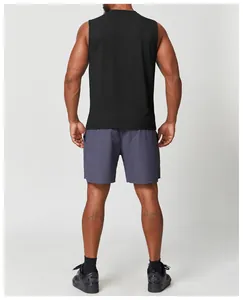 Vista posteriore della canotta fitness nera senza maniche da uomo con shorts grigi