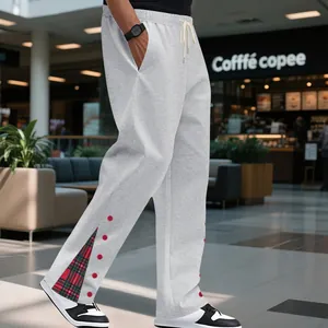 Primo piano di pantaloni sportivi grigi da uomo con dettaglio spacco laterale scozzese.