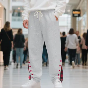 Dettaglio dei pantaloni sportivi grigi da uomo con pois rossi e spacchetti a quadri.