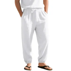 Close-up of men's white drawstring linen joggers with elastic cuffs and pockets.