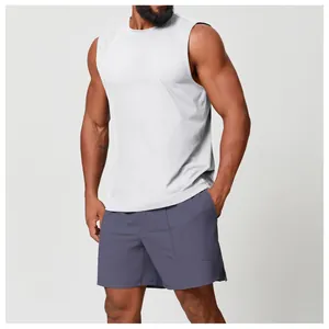 Modello che indossa top fitness bianco senza maniche e pantaloncini viola in studio
