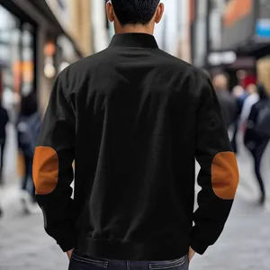 Back view of men's black bomber jacket with brown corduroy elbow patches