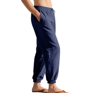 Side view of loose navy linen joggers for men featuring a drawstring and elastic cuffs.