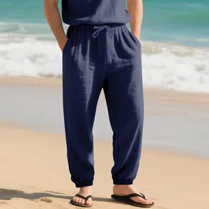 Detail of men's navy blue linen jogger pants with drawstring waist on the beach