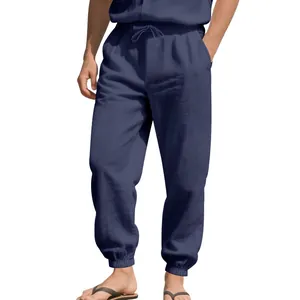 Close-up of navy blue men's linen jogger pants with drawstring waist and cuffed hem.