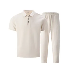 Close-up detail of men's cream textured jacquard polo shirt and matching pants