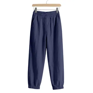 Detail of navy blue men's linen joggers with elastic drawstring waist and cuffed ankles.