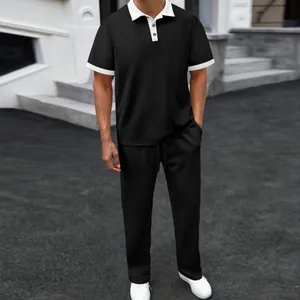 Close-up view of men's black summer jacquard polo shirt and matching trousers casual sports set