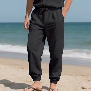 Detailed shot showing the texture of men's loose black linen jogger pants with drawstring waist