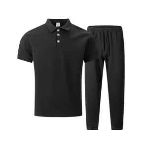 Detail view of men's black textured jacquard Polo shirt and pants casual set.