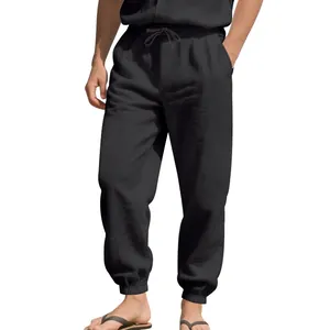 Detailed view of men's loose black linen jogger pants featuring a comfortable drawstring waist.
