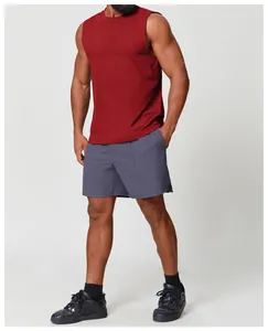 Uomo sportivo che indossa una canotta senza maniche bordeaux e pantaloncini grigi
