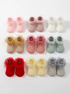 Display of nine pairs of colorful infant socks with elegant double-layered lace ruffles