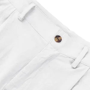 Gros plan sur la taille d'un pantalon en lin blanc avec bouton marron et passants.