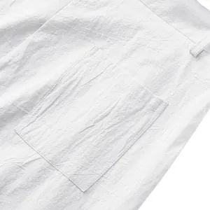 Gros plan d'un pantalon d'homme en lin blanc montrant le détail de la poche et la texture.