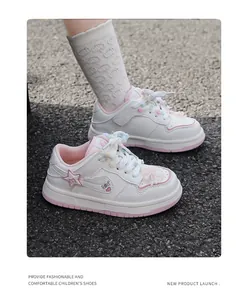 Detailansicht weißer Mädchen-Sneaker mit rosa Akzenten und buntem Herz-Stern-Muster.