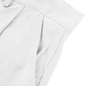 Détail rapproché du pantalon décontracté en lin blanc montrant la poche et la taille