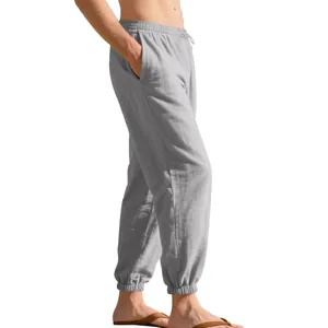 Side view detail of men's loose linen jogger pants in light grey with drawstring waist