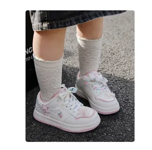 Nahaufnahme weißer Mädchen-Sneaker mit rosa Sternen und bunten Plüschschnürsenkeln.