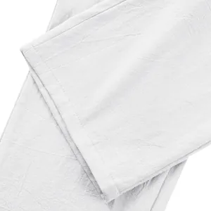 Gros plan macro détaillé montrant la texture du tissu en lin blanc respirant du pantalon