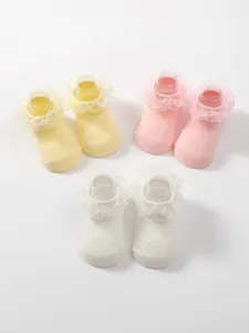Three pairs of pastel baby socks with elegant lace ruffle detailing