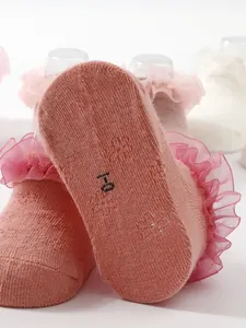 Close-up of pink ruffle baby sock sole showing soft cotton texture and size marking