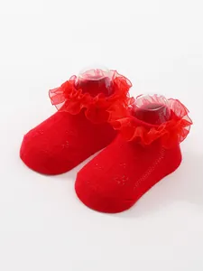 Detailed close-up of red ruffled princess baby socks with breathable knit texture.