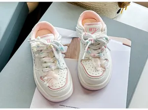 Stilvolle weiße Mädchen-Sneaker mit rosa Akzenten, Bommelschnürsenkeln und Blumen.