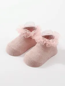 Close-up of pink breathable ruffle socks for baby girls with elegant ballet style lace