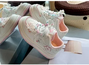 Detailaufnahme der pink-weißen Mädchen-Sneaker mit dekorativen flauschigen Schnürsenkeln