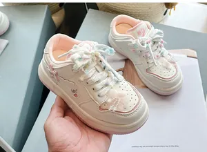 Nahaufnahme von stylischen rosa-weißen Mädchen-Sneakern mit flauschigen Schnürsenkeln