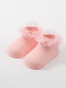 Detailed view of pink breathable baby socks with elegant ruffle lace trim design