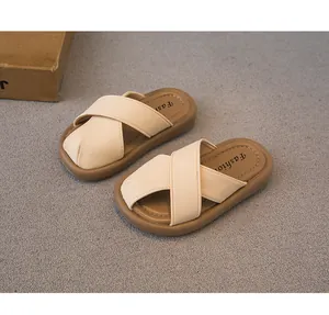 Detalle de pantuflas beige para niños con diseño de correas cruzadas y suela blanda