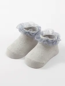 Detailed macro view of baby princess socks featuring breathable knit and blue lace ruffles