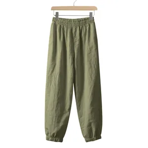 Full view of men's loose olive green linen joggers for summer on a wooden hanger.