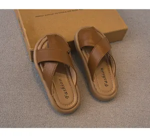 Vista detallada de sandalias marrones para niños con correas cruzadas y suela blanda