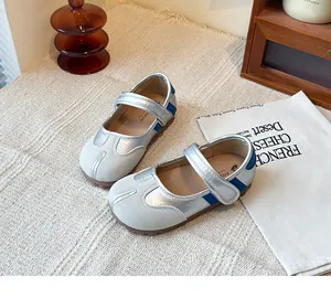 Vista detallada de los zapatos Tabi Mary Jane plateados con punta dividida y azul.