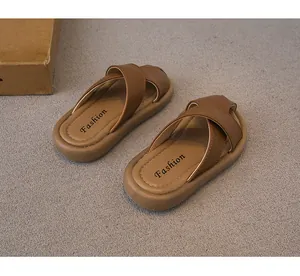 Vista detallada de sandalias marrones para niños con correas cruzadas y suela suave