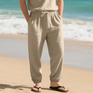 Detail view of men's loose linen jogger pants with drawstring waist at the beach