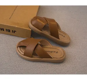 Primer plano de pantuflas marrones para niños con correas cruzadas y suelas blandas