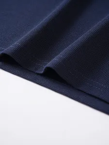 Macro detail of navy blue jacquard fabric texture and premium stitching on polo shirt