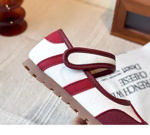 Vista detallada de los zapatos Mary Jane rojos y blancos con cierre de tira adhesiva