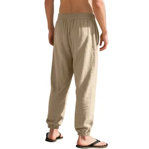 Back view of men's loose linen joggers in beige with elastic cuffs and textured fabric